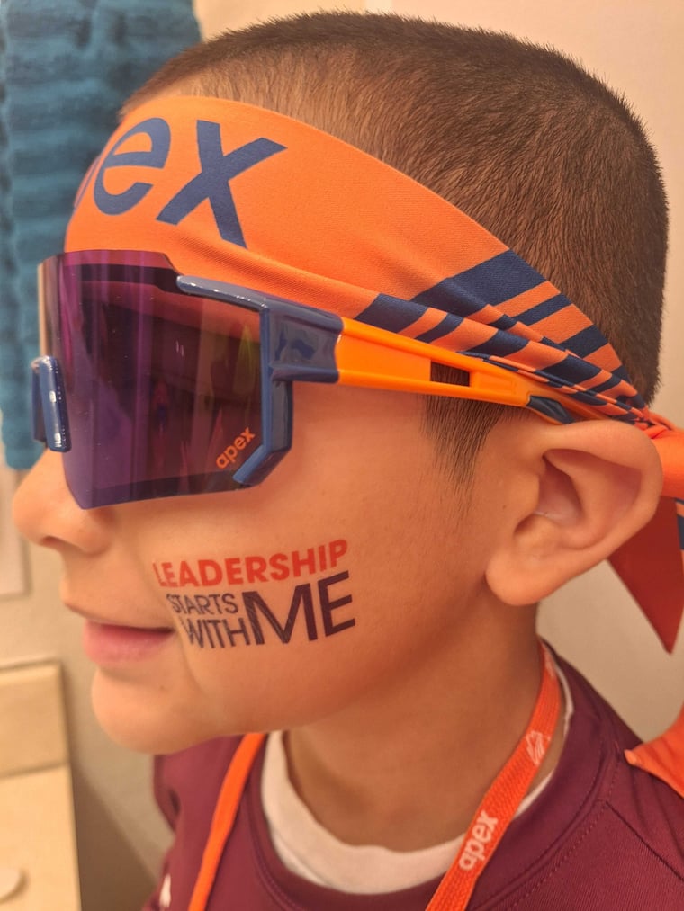 Student in an Apex headband and sunglasses with Leadership Starts With Me face paint