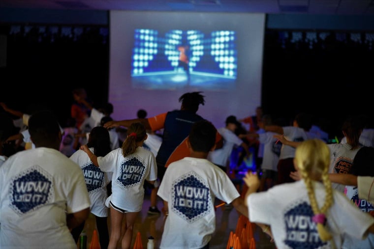 Students dancing in front of a big screen at an Apex Remix dance party