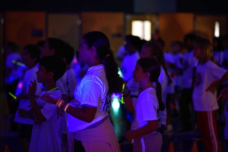 Students dancing under blue lights at an Apex Remix event