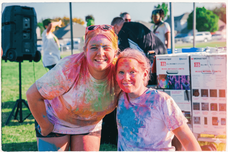 Teacher and student covered in color powder at an Apex Color Games event
