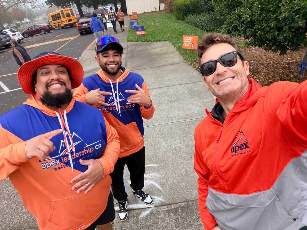 Apex San Diego coaches smiling outside a school during drop-off
