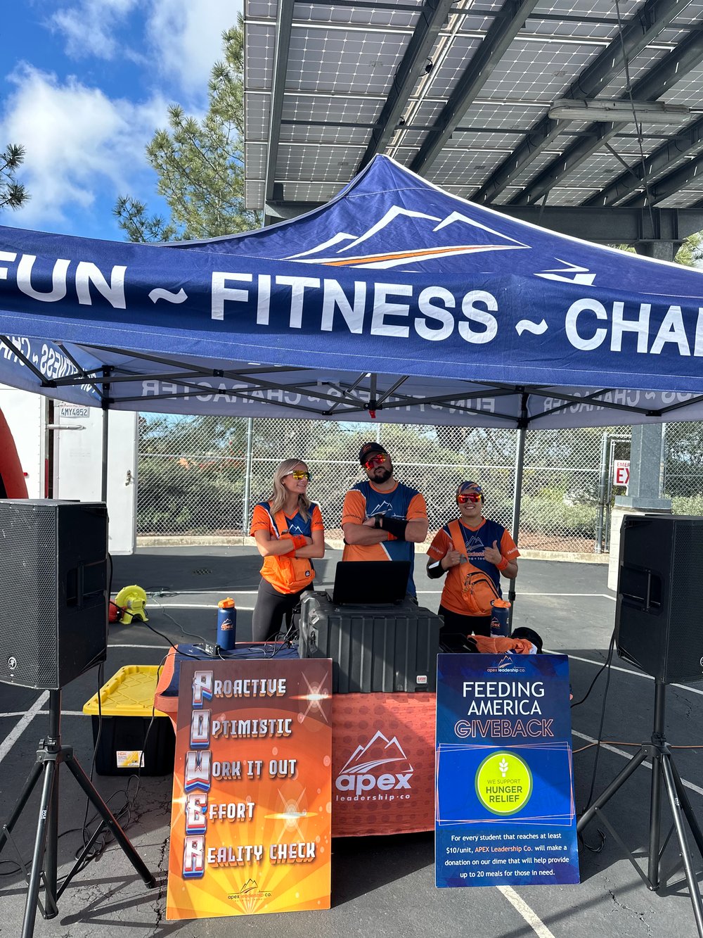 Three Apex San Diego coaches running the music booth under an Apex tent