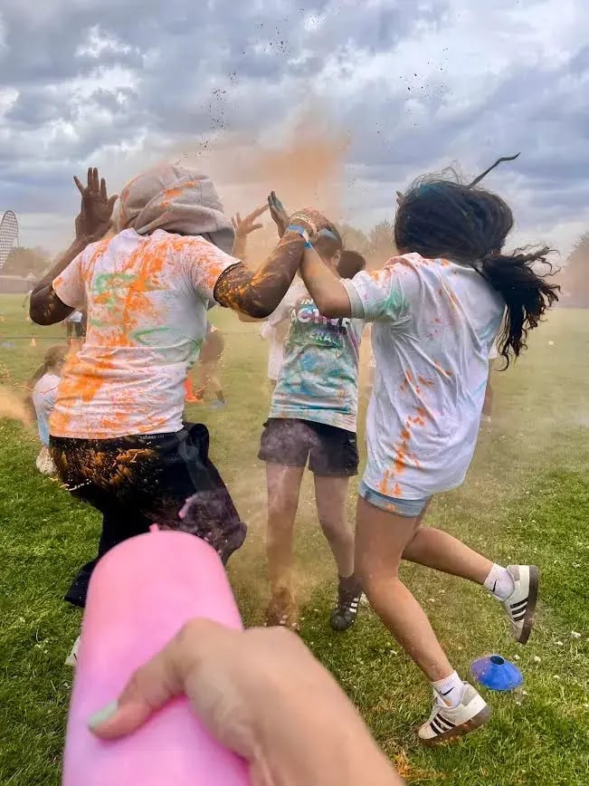 Students running through clouds of color powder at an Apex Color Games event